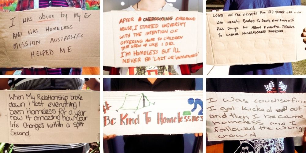 People holding cardboard with written stories of homelessness