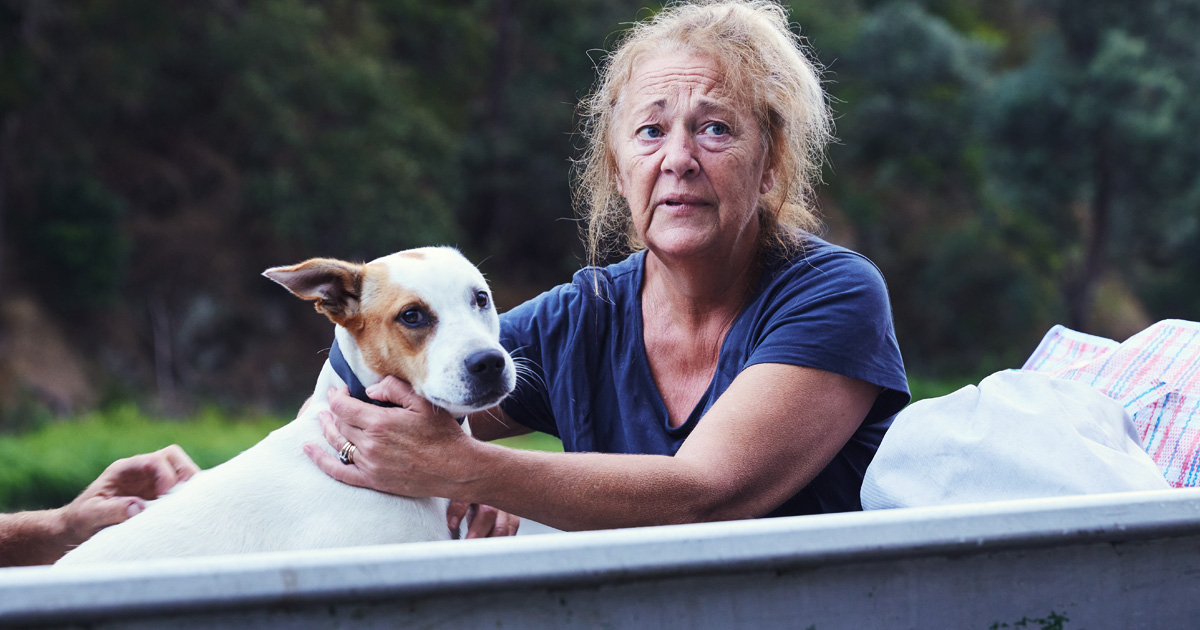 Woman hugs her dog after losing home in floods
