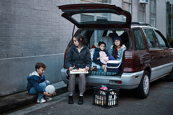 Mum and kids having dinner in the car they are living in. Domestic and family violence is a leading cause of homelessnesss in Australia.