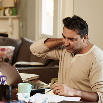 A man looking stressed at a computer