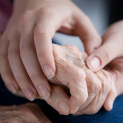 Child holding an elderly woman's hand