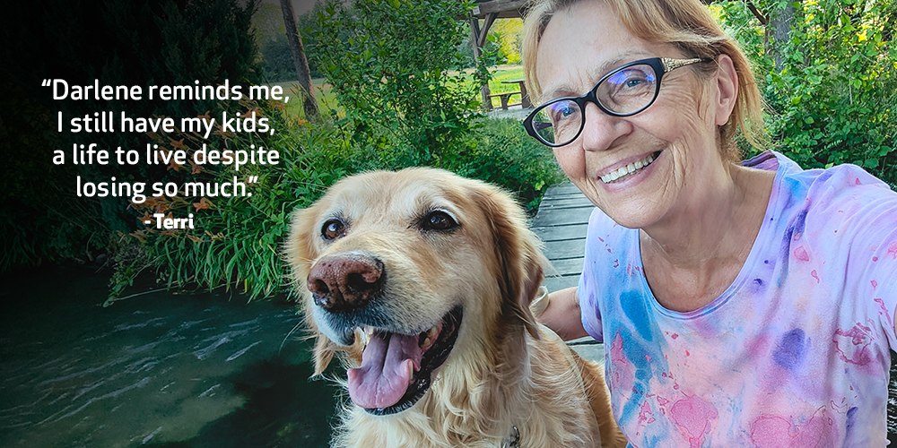 Terri takes a photo with her dog. Text on image reads. ‘Darlene reminds me, I still have my kids, a life to live despite losing so much.’ - Terri