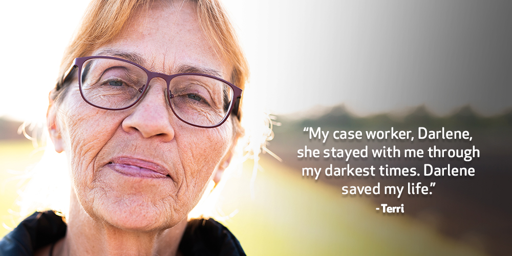 A blonde-haired middle-aged lady wearing glasses is pictured standing outside in the sun. Text on image reads. ‘My case worker, Darlene stayed with me through my darkest times. She was this constant presence. Darlene saved my life.’ - Terri