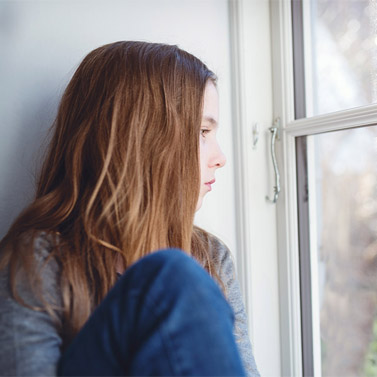 Young person looking out window