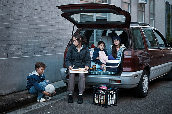 Mum and kids having dinner in the car they are living in. Domestic and family violence is a leading cause of homelessnesss in Australia.