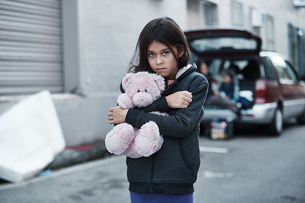 Young girl preparing to sleep in a car overnight. Over 15,800 children younger than 12 years are homeless.