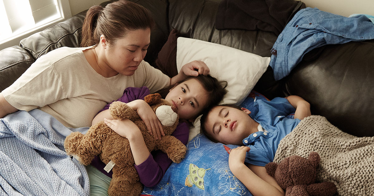 A sad homeless family on couch surfing