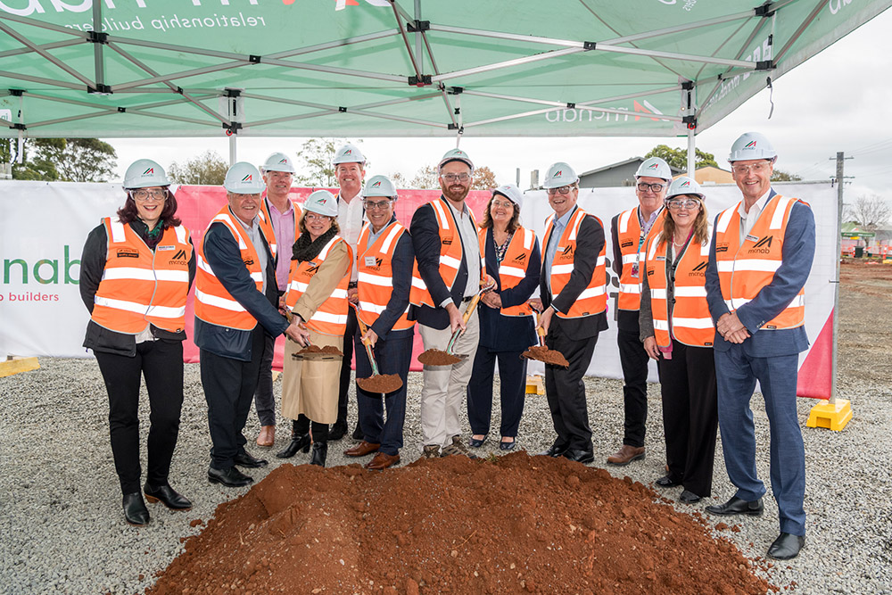 Toowoomba housing with executives holding shovel in their hand.