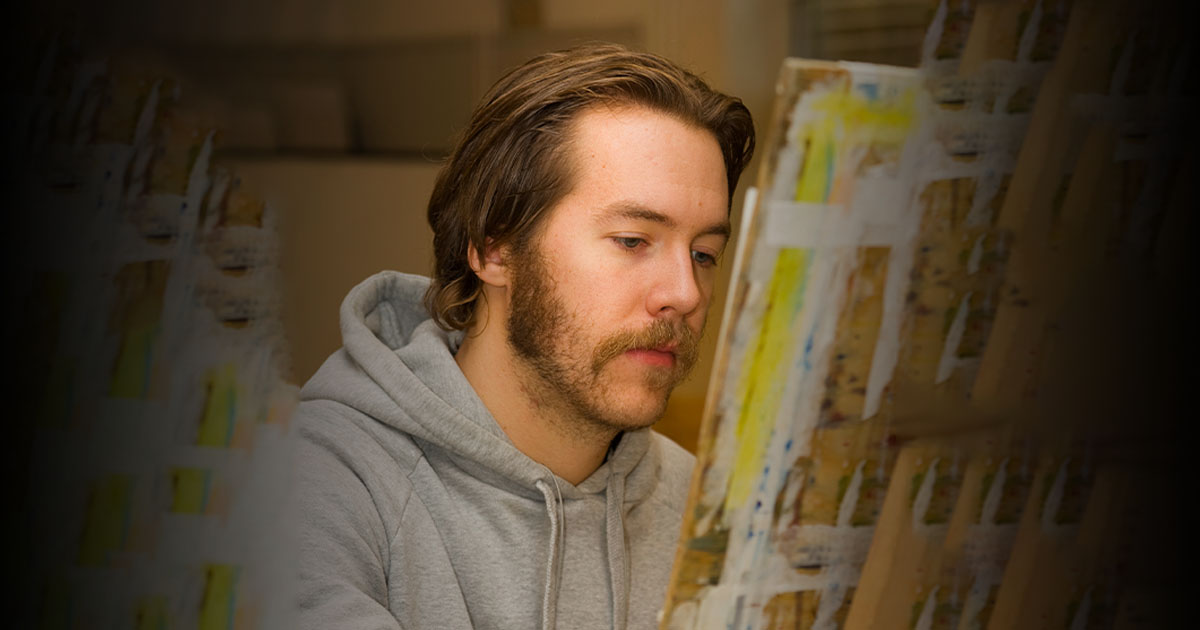 An artist is focusing on his artwork