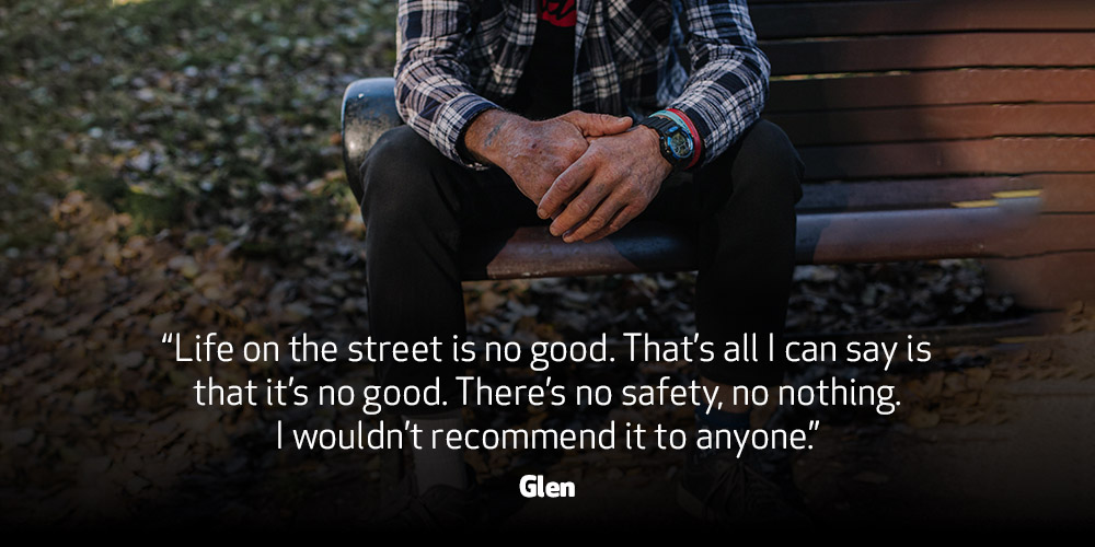 Hands of a man sitting on a bench. Text on the image: “Life on the street is no good. That’s all I can say is that it’s no good. There’s no safety, no nothing. I wouldn’t recommend it to anyone.”  - Glen