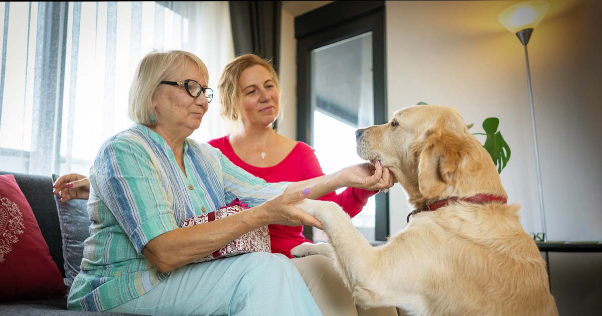 Janelle and her mum patting their dog