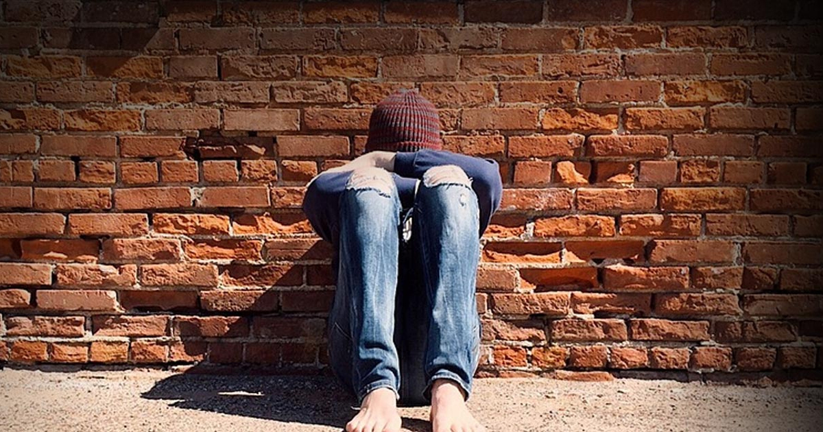 Man sitting against a wall