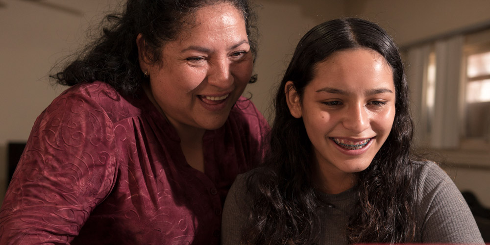 Mother and teenage daughter smiling