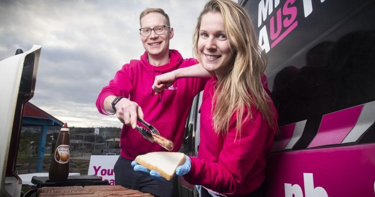 Youth beat team smiling and making sausages for the community. 