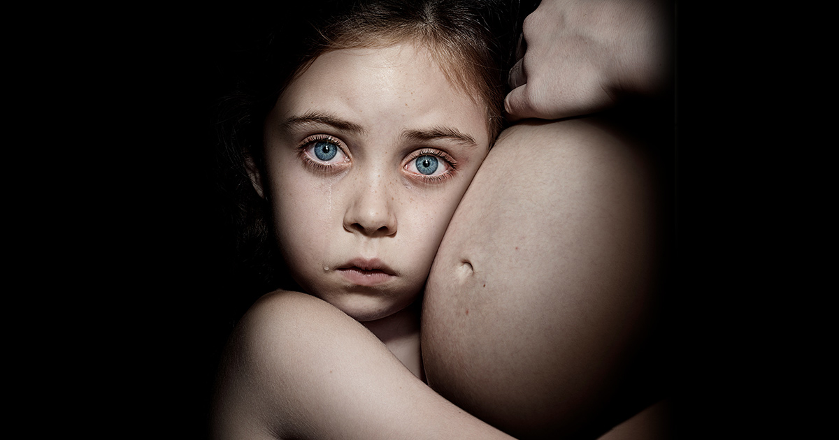 Little girl holding her Mum's belly