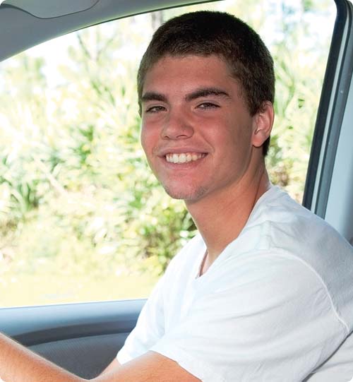 Corey smiling whilst learning to drive a car