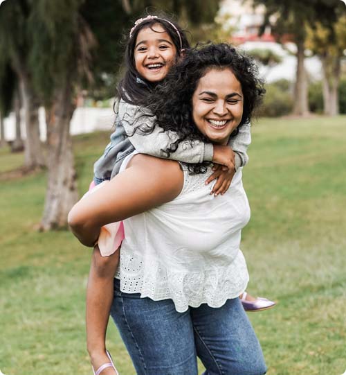 Julia smiling and holding young daughter