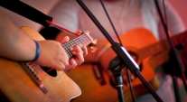 People playing a guitar on stage