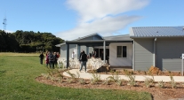 Triple Care Farm building with people gathering outside